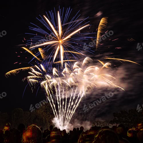 Preview: Spectacular view of a crowd watching beautiful fireworks explode in a smoky sky at night