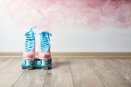 Preview: Vintage roller skates on floor near color wall. Space for text