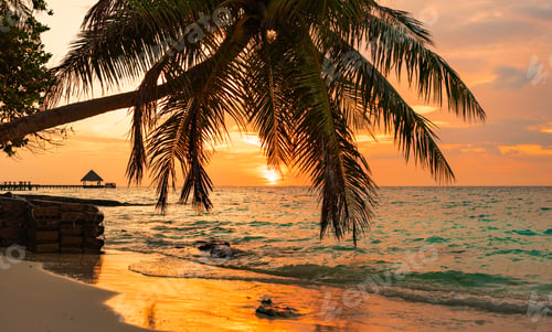 Preview: picturesque sunrise in the Maldives island, the sun rising from the Indian ocean and reflected in th