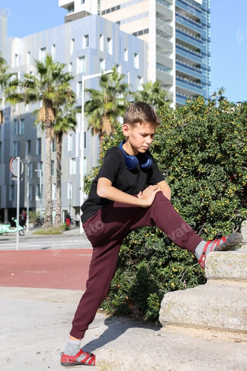 Preview: Handsome teenager doing exercises outdoors