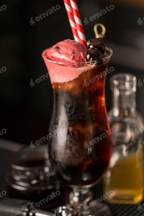 Preview: Vertical closeup of black cherry cocktail with straw