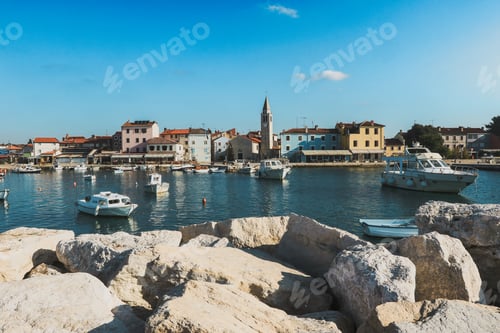 Preview: Pula Croatia with boats docked by the rocky shore and charming waterfront buildings
