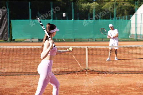 Preview: Woman and man playing tennis at court