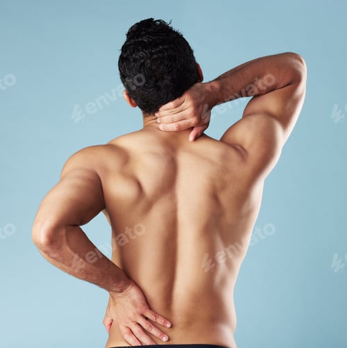Preview: Rearview young mixed race man standing shirtless in studio isolated against a blue background. Unre