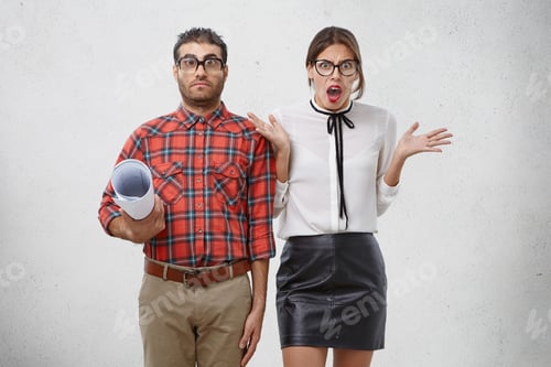 Preview: Young pleasant looking female being irritated with male colleague, gestures in discontent, asks why