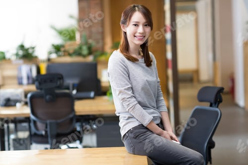 Preview: Young woman sitting in office