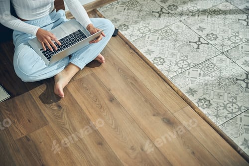 Preview: Young woman working on her laptop indoors
