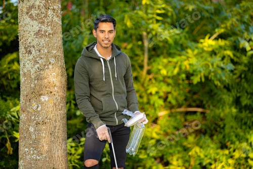 Preview: Male volunteer holding garbage and mechanical grabber