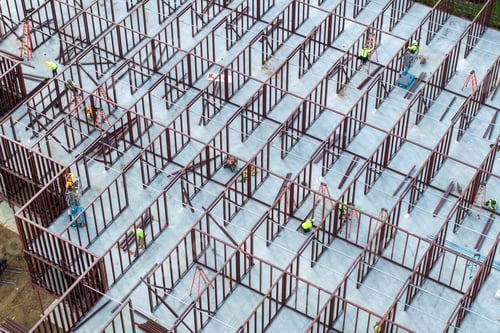 Preview: Industrial construction site with workers assembling metal frame building