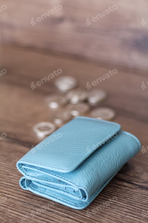 Preview: Blue wallet and coins on a wooden background.