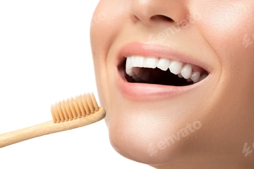 Visualização: Boca feminina com dentes brancos e escova de dentes de bambu