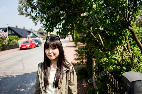 Preview: Young woman enjoying a sunny day on a suburban street