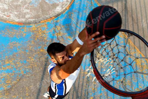 Preview: Top view of young man playing basketball outdoor. Slam dunk.