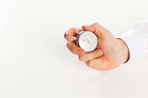 Preview: Close up of hand holding stopwatch, isolated on white background