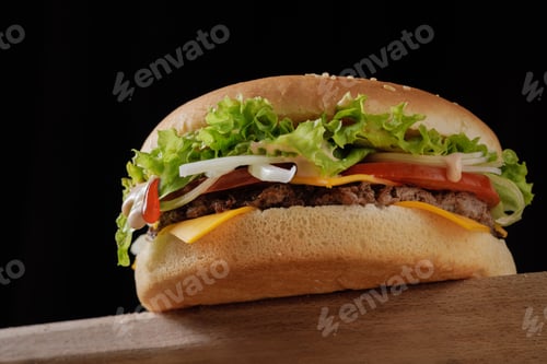 Preview: perfect tasty big cheeseburger on wooden table on brown background, bottom view