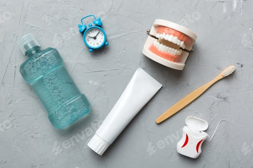 Preview: Mouthwash and other oral hygiene products on colored table top view with copy space.