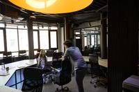 Preview: Businessman and businesswoman talking during work in large coworking office