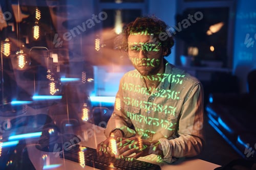 Preview: Guy in green beams works on computer in dark office room