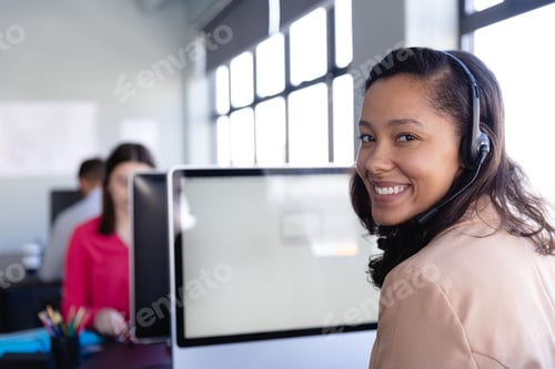 Preview: African American woman working with headset phone in office