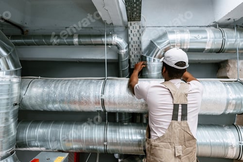 Preview: Skilled worker installing metal ductwork in a commercial building during a maintenance project