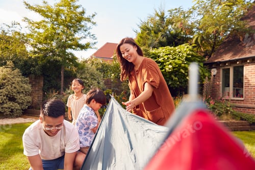 Preview: Asian Family In Garden At Home Putting Up Tent For Camping Trip Together