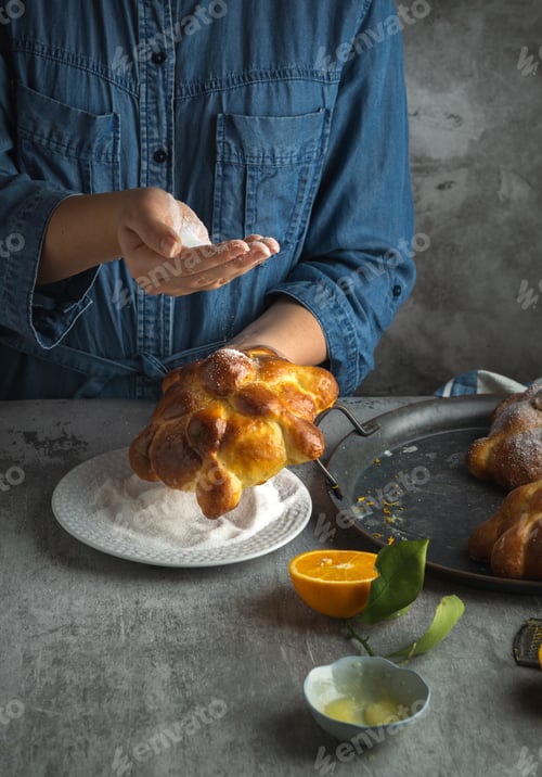 Preview: Woman preparing Pan de muertos bread of the dead for Mexican day of the dead