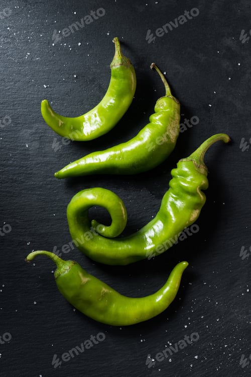Preview: top view of green ripe chili peppers on black surface