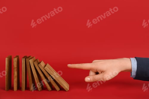 Preview: Woman causing chain reaction by pushing domino tile on red background, closeup. Space for text