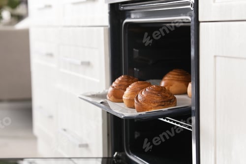 Preview: Open oven with tray of freshly baked buns in kitchen