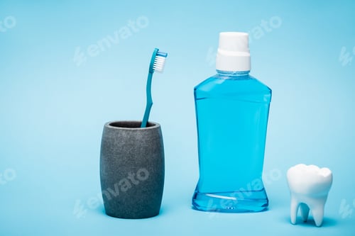 Preview: Toothbrush, tooth model and bottle of mouthwash on blue background