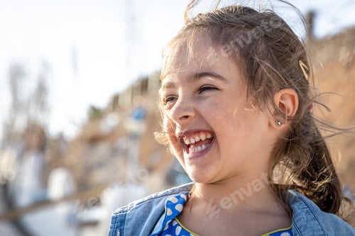 Preview: Portrait of a funny smiling girl in sunny weather.