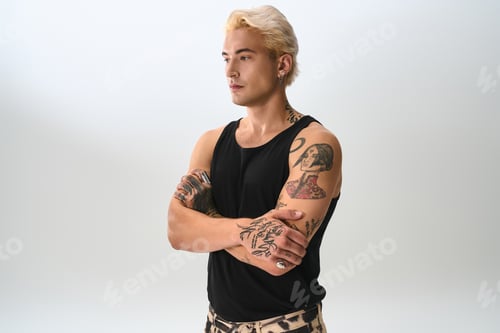 Preview: Young man showcases stylish fashion with confidence in a modern studio setting