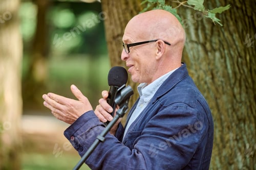 Preview: Outdoor lecture on amber jewellery by bald mature man