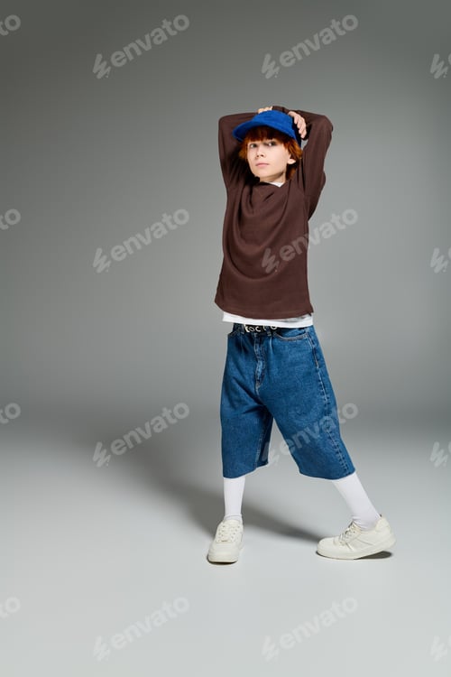 Preview: Casual style shines as young boy with red hair showcases creativity in studio setting