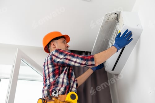 Preview: Professional technician maintaining modern air conditioner indoors