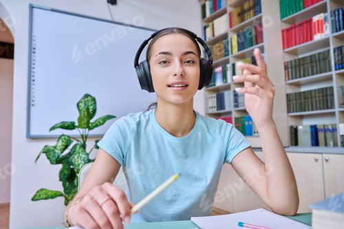 Preview: Webcam view of teenage girl, high school student, in headphones, talking to camera
