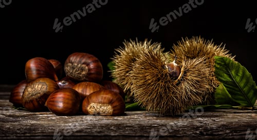 Preview: Chestnuts and chestnut bur on wooden table.