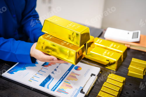 Preview: An Asian business woman sitting at her desk in office,analyzing gold bullion prices,market trends