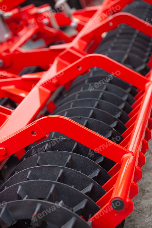 Preview: Closeup vertical shot of a red stubble cultivator on a sunny day