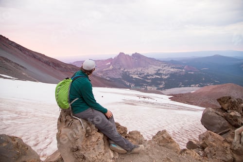 Preview: Young man sitting at the summit of South Sister volcano, Bend, Oregon, USA
