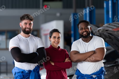 Preview: Portrait of two guy professional auto technician and a female customer standing in auto repair shop