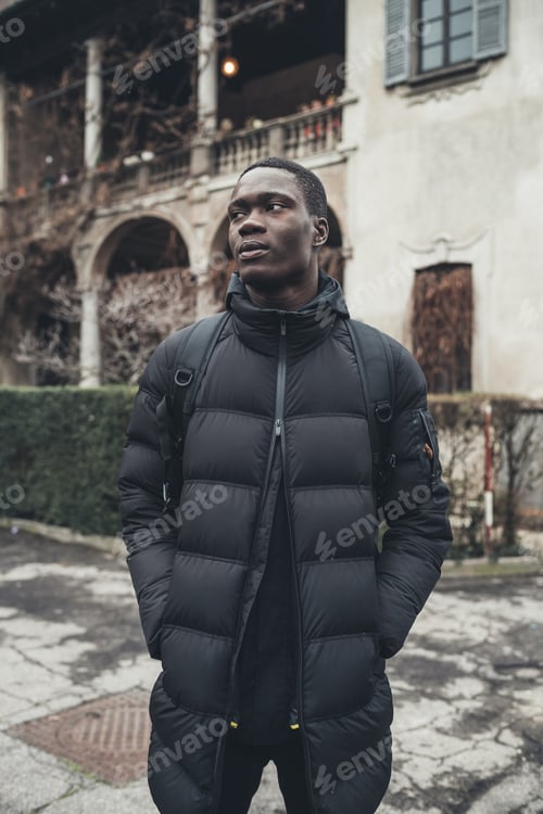 Preview: portrait young african man standing alone and looking further