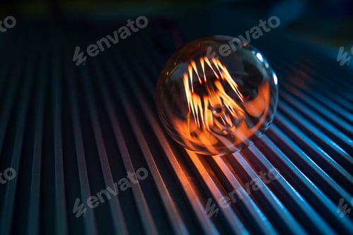 Preview: Illuminated Lightbulb Shines on Metal Surface