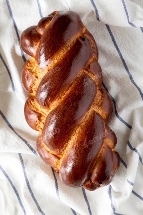 Preview: Homemade jewish challah bread on cloth, overhead view. From above, top view, flat lay.