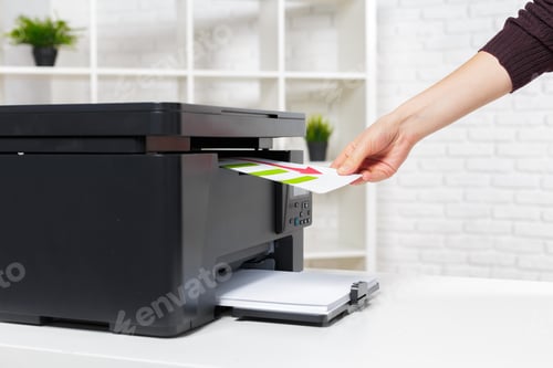 Preview: Person inserts paper into a printer in a bright indoor workspace