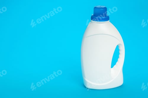 Preview: Clear bottle with blue lid stands on bright blue background for cleaning purpose