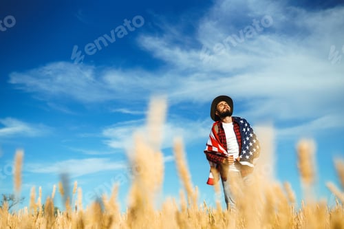 Preview: 4th of July. American Flag. Traveler with the flag of America. The man in a hat, a backpack.