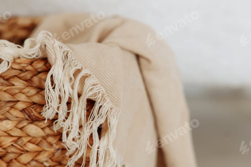 Preview: Beautiful beige linen fabric rests inside a rustic woven basket.