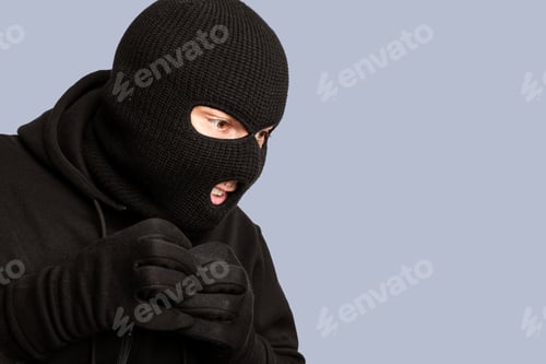 Preview: Portrait of masked thief isolated over white studio wall