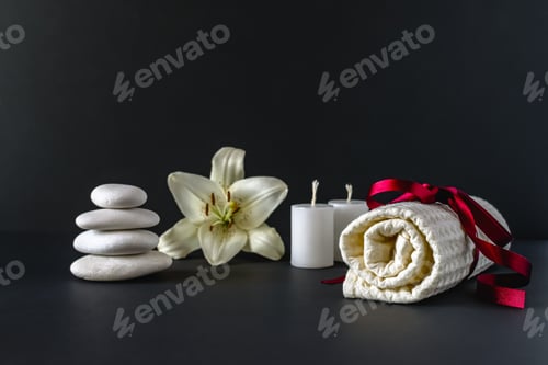 Preview: Spa still life with scented candles, stones, flowers and a bath towel. Horizontal photo. Horizontal
